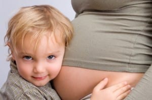 Little boy hugging his mother belly.