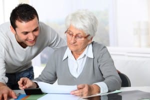 Young man helping elderly woman with paperwork